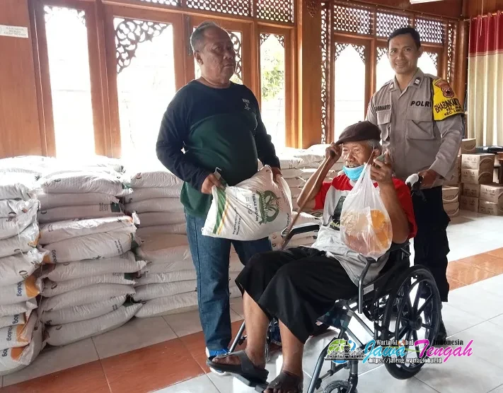Aksi Humanis! Bhabinkamtibmas Jajar Bantu Dorong Kursi Roda Lansia saat Antere Bansos Sembako